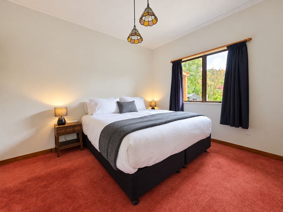 Bedroom with queen bed, pendant light and bedside lamps