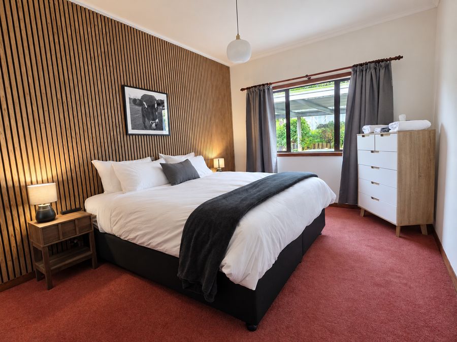 Bedroom with slatted timber feature wall, cow print and king bed