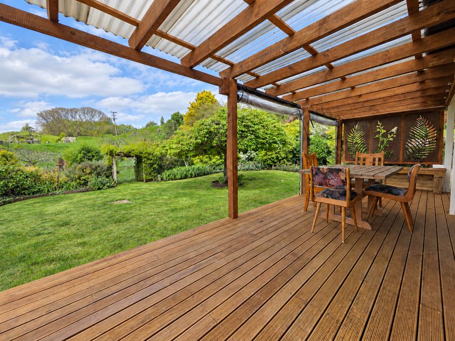 Pergola deck with outdoor dining table beside the garden
