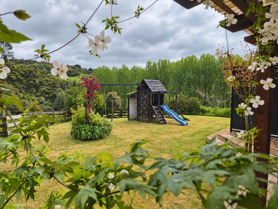 Garden and play fort seen through white blossoms