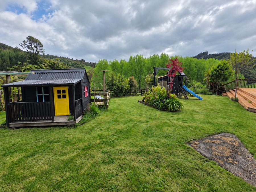 Children's playhouse with a yellow door on the lawn